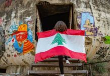 Une fille arborant le drapeau libanais à l'entrée de l'Oeuf, structure en béton du Centre ville de Beyrouth. Photographie circulant sur les réseaux sociaux. Crédit Photo: DR (droit réservé)