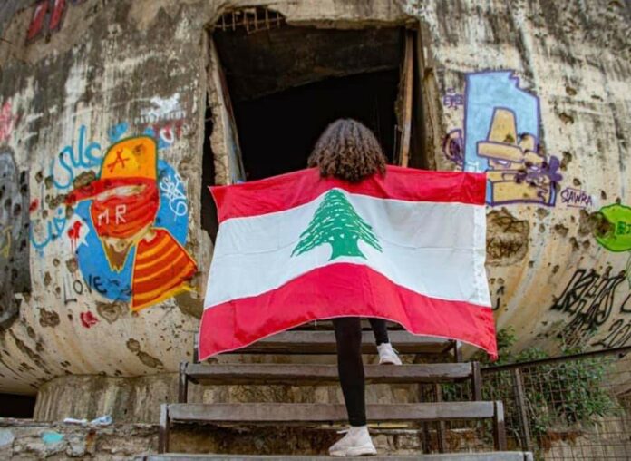 Drapeau - Oeuf - Centre ville de Beyrouth - Photo Facebook Une fille arborant le drapeau libanais à l'entrée de l'Oeuf, structure en béton du Centre ville de Beyrouth. Photographie circulant sur les réseaux sociaux. Crédit Photo: DR (droit réservé)