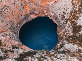 close up photography of hole and body of water