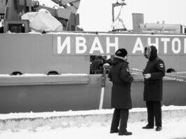 black and white photo of russsoldiers talking in front of warship