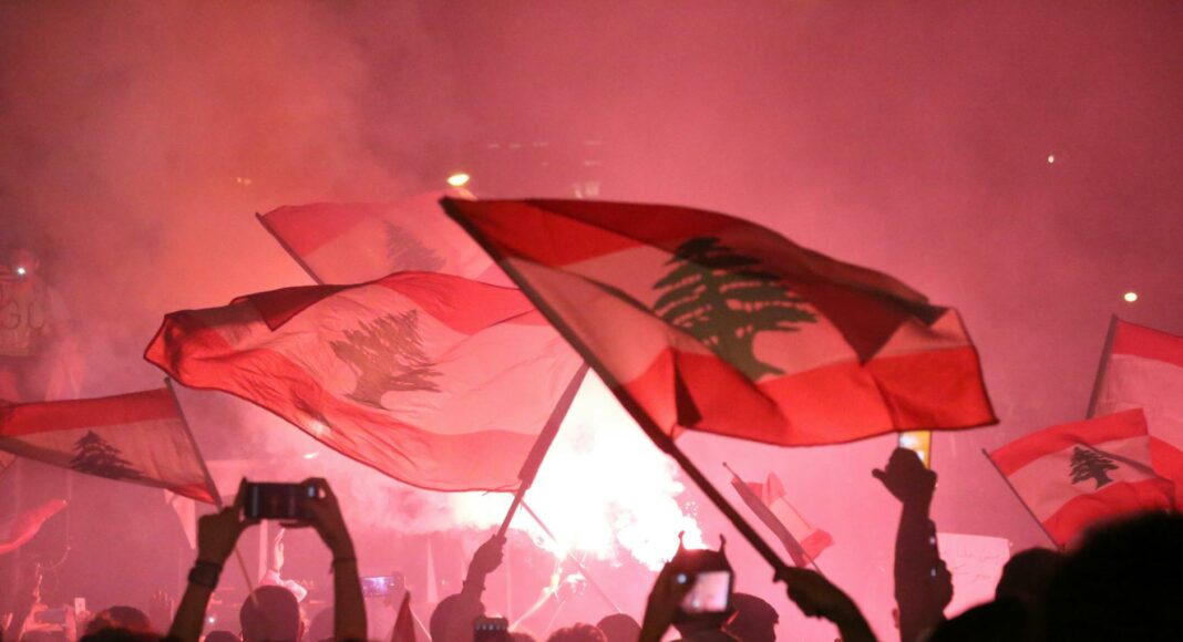 a crowd gathered in a concert waving flags