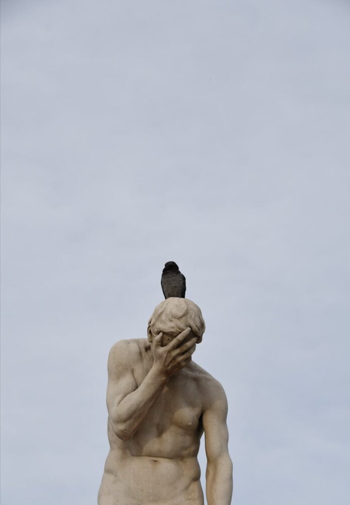 pexels-photo-19190220 bird on the sculpture of a distraught cain in paris tuileries garden