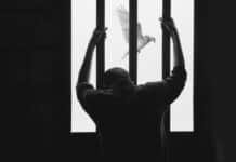 man in black long sleeve shirt raising his right hand