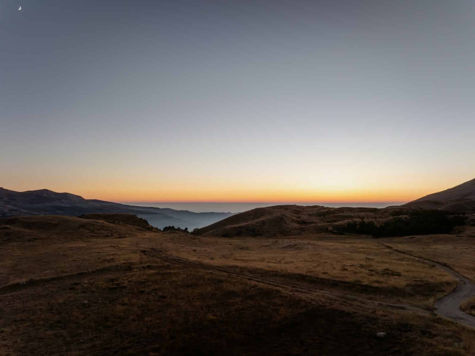 The sun is setting over a mountain range