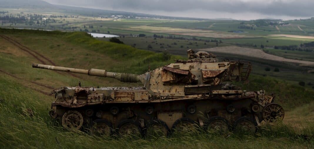 a military tank driving through a field