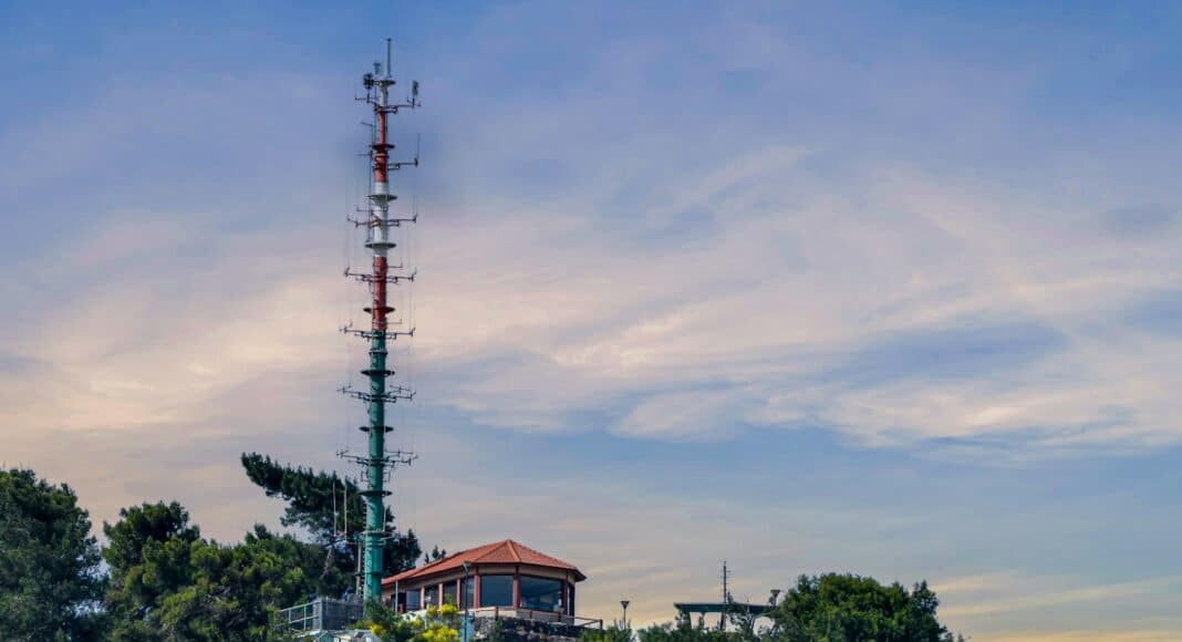 A very tall tower sitting on top of a lush green hillside