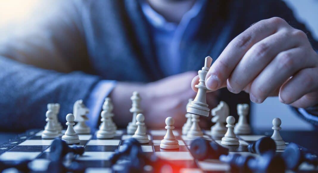 depth of field photography of man playing chess