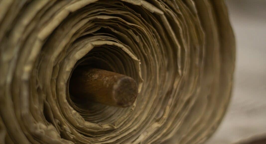 brown wooden rolling pin on white textile